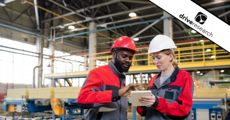 workers in a manufacturing plant going over the market research options