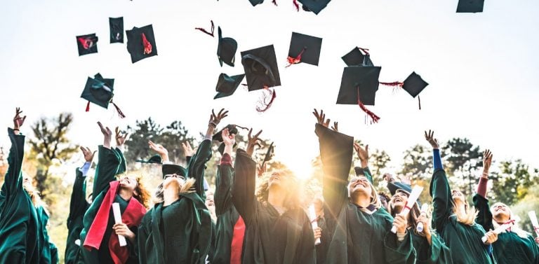 Students at graduation throwing caps