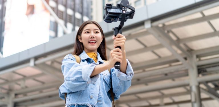 Female vlogger in city area with camera