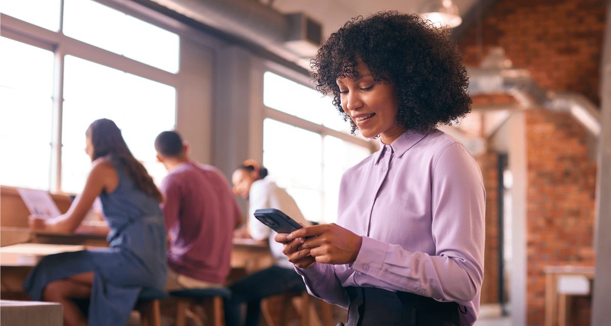 Woman sitting smiling and taking mobile survey on phone