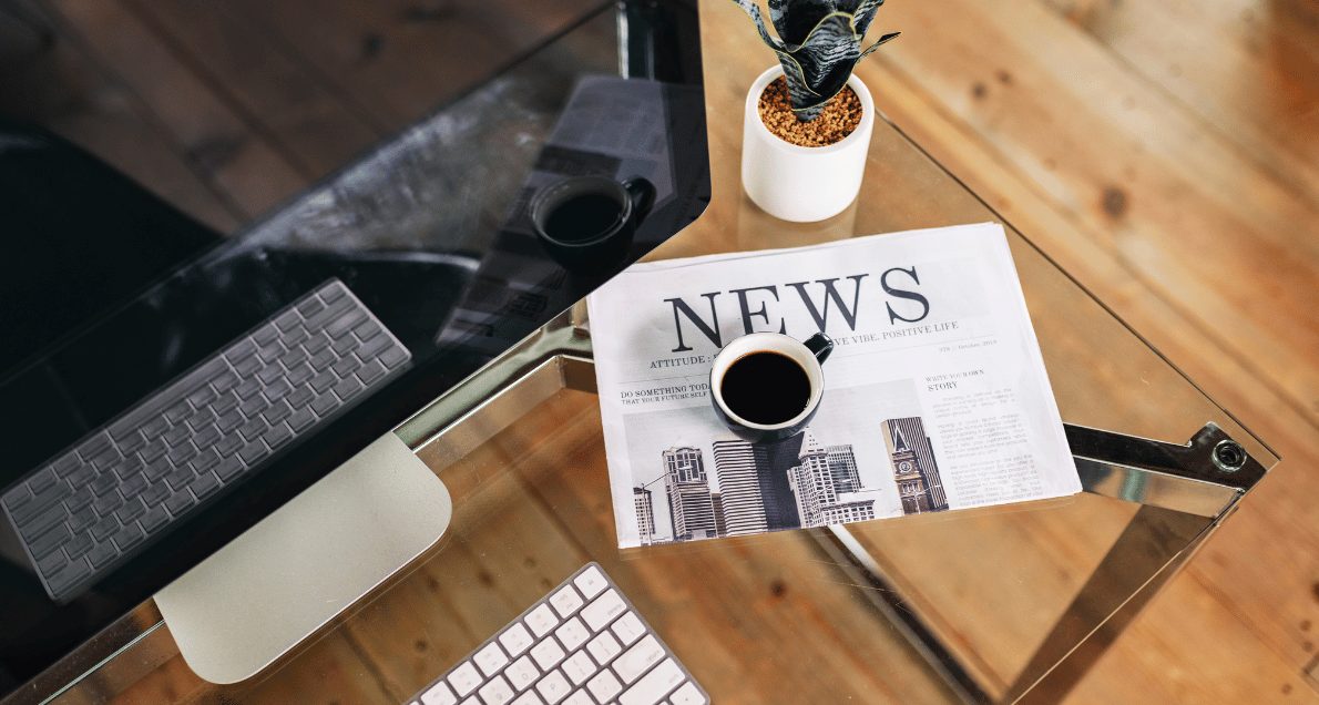 Desk with newspaper and coffee on it