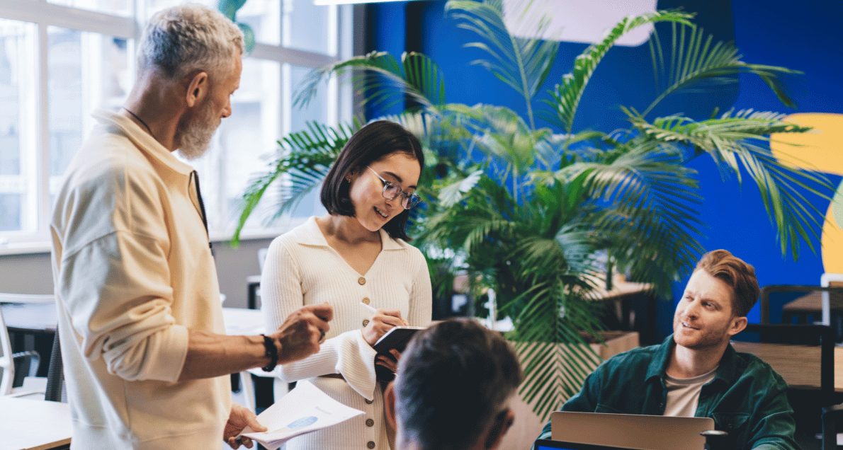 Employees working together around a desk at the office