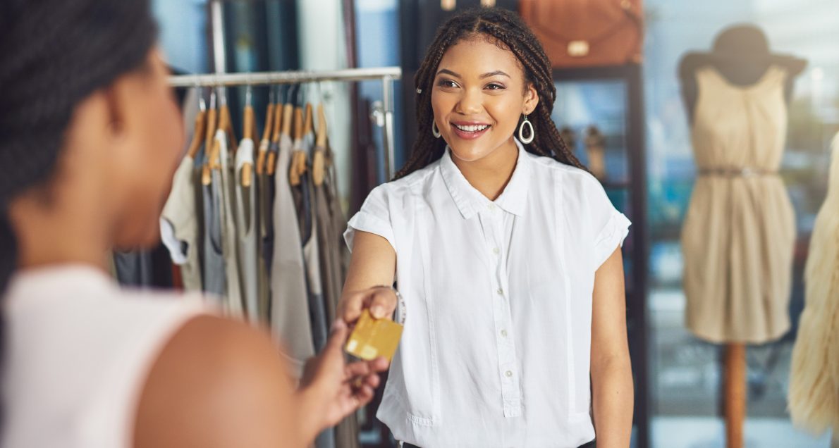 Female retail worker giving credit card to customer