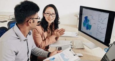 Man and woman sitting at desk discussing content marketing research data