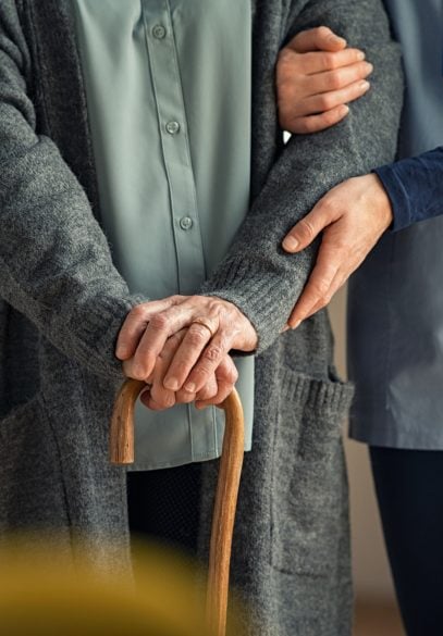 Nurse Assisting Senior with Walking Cane