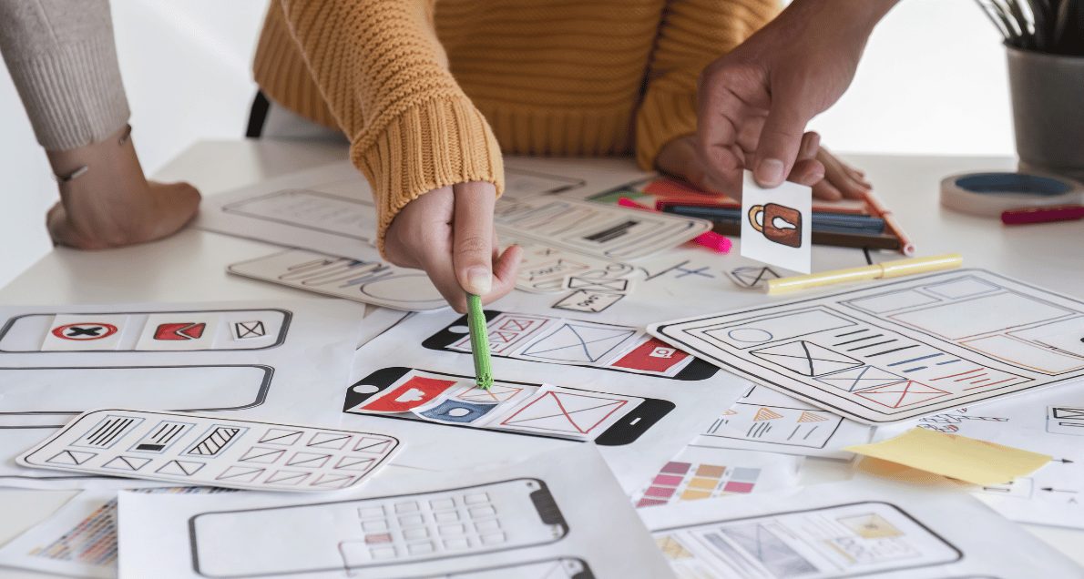 People brainstorming UX design ideas for a mobile app on a paper