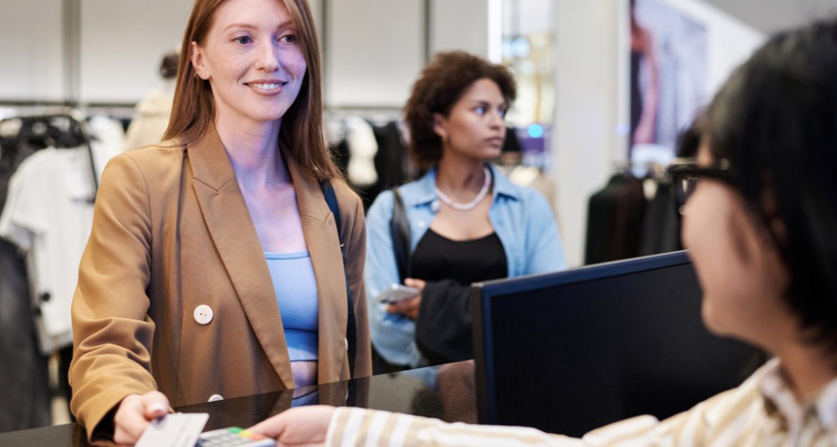 Redhead Girl Paying with Credit Card at Clothing Store