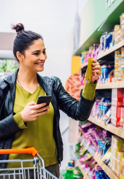 Woman shopping in grocery store looking at food product