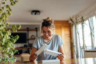 Young woman looking at gift packaging in her home