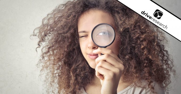 Woman looking through a magnifying glass