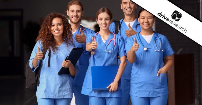 Nurses in scrubs smiling with thumbs up