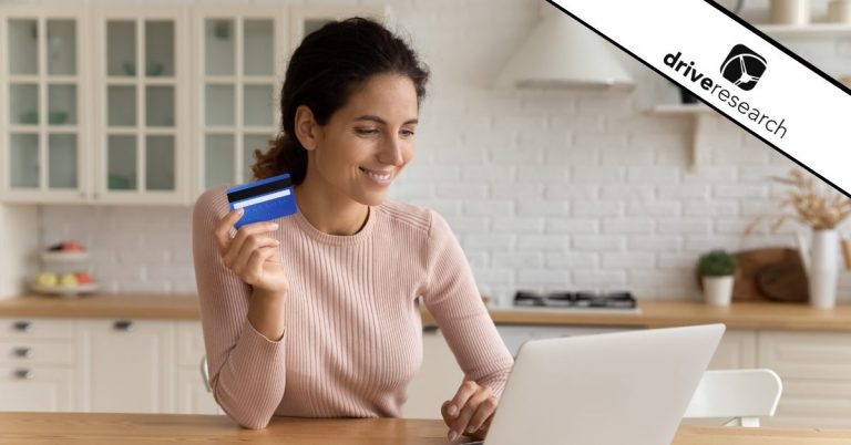 Woman smiling in front of computer with credit card