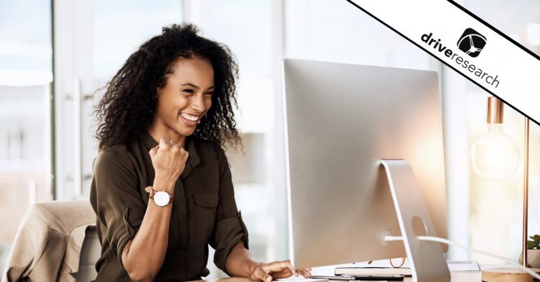 Woman smiling at her desk in front of computer