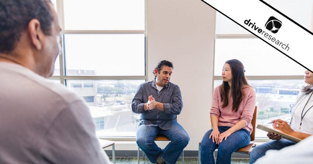 a focus group being conducted with a moderator collecting qualitative data