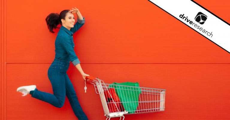 Woman in front of orange wall with a shopping cart