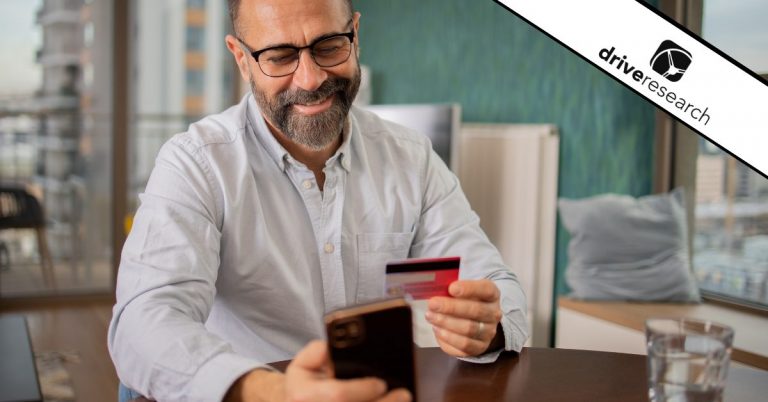 Male with white shirt checking out on his phone with a red credit card