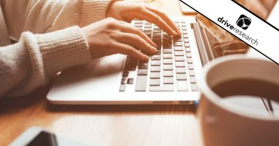 Person typing at desk next to coffee