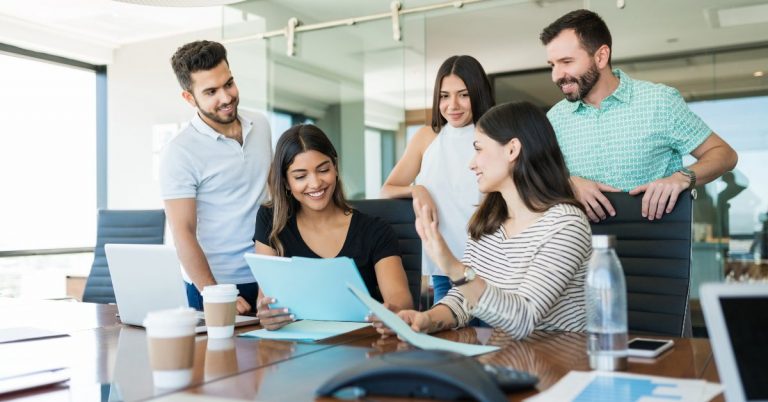 Male and female co workers at a conference desk with coffee