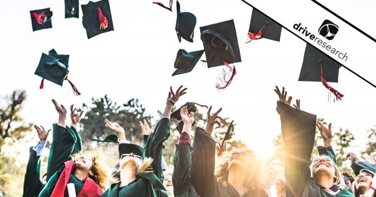 Graduates throwing graduation caps in air