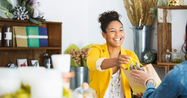 Female giving a gift bag to a customer