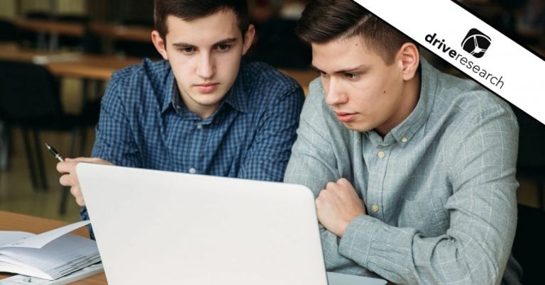 Two males working on the same laptop