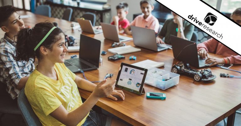 EdTech employees around desk on their laptops