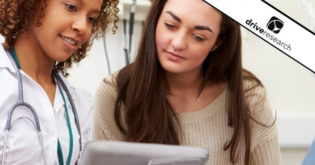 Female patient looking at tablet with doctor