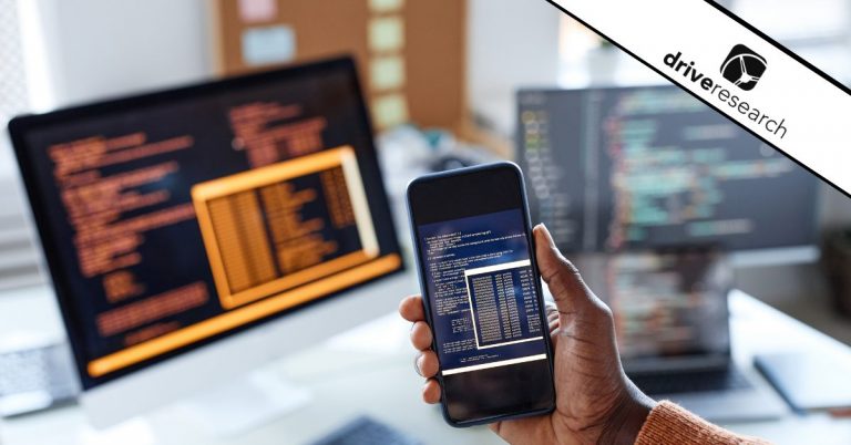 a man holding up a phone in front of 3 screens showing testing from monadic testing happening