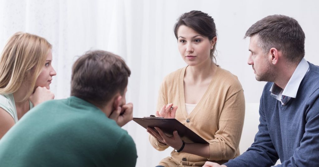 a woman speaking to a focus group showing how to moderate a focus group and the role