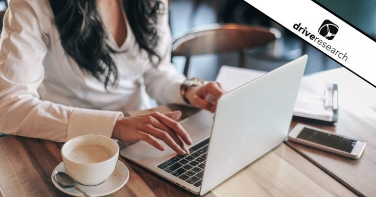 Female typing on a laptop in a coffee shop - Drive Research