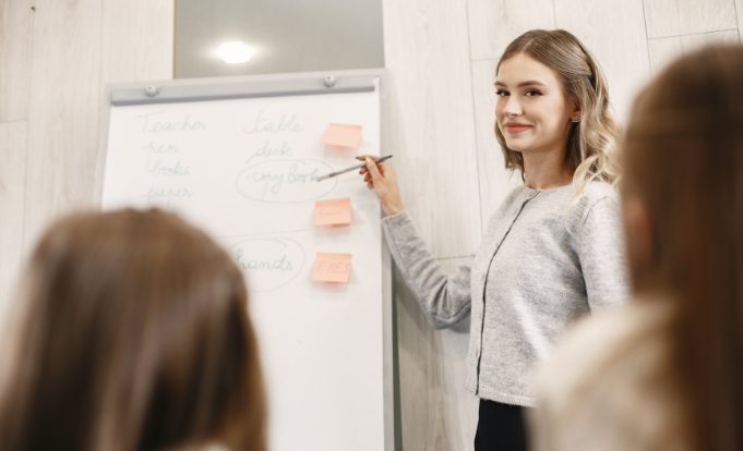 A Teacher Discussing in Front of the Whiteboard