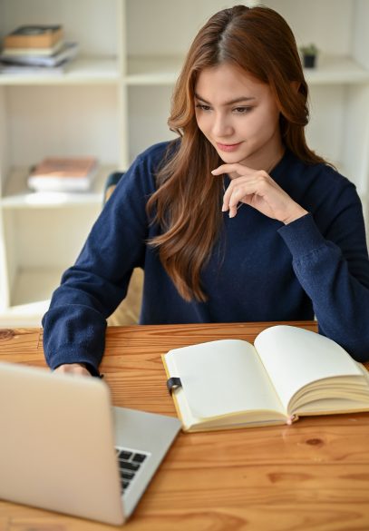 Female looking at computer with note pad