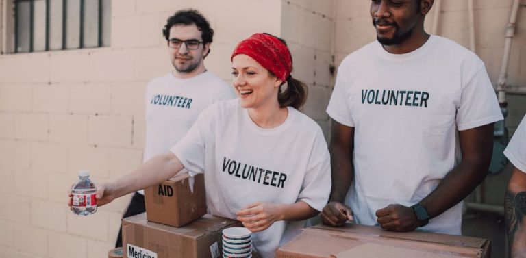 Female volunteer passing out water with male volunteers