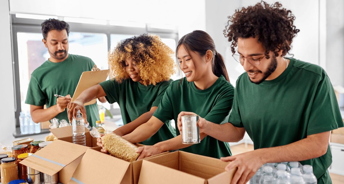 Happy Volunteers Packing Food in Donation Boxes