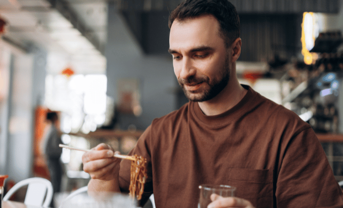 Man eating pasta at a restaurant