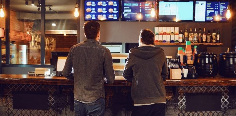 Two men ordering at fast food restaurant