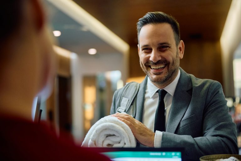 Happy businessman talking to a receptionist while checking in at the gym