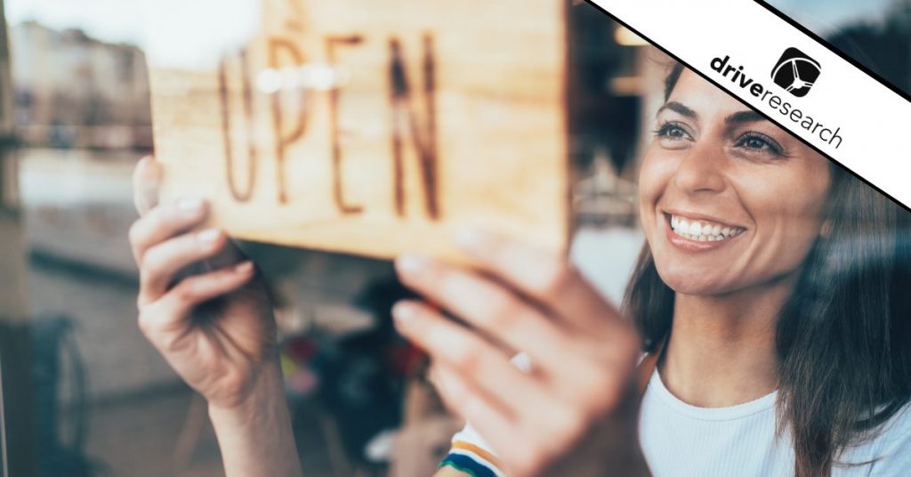 Female business owner hanging open sign