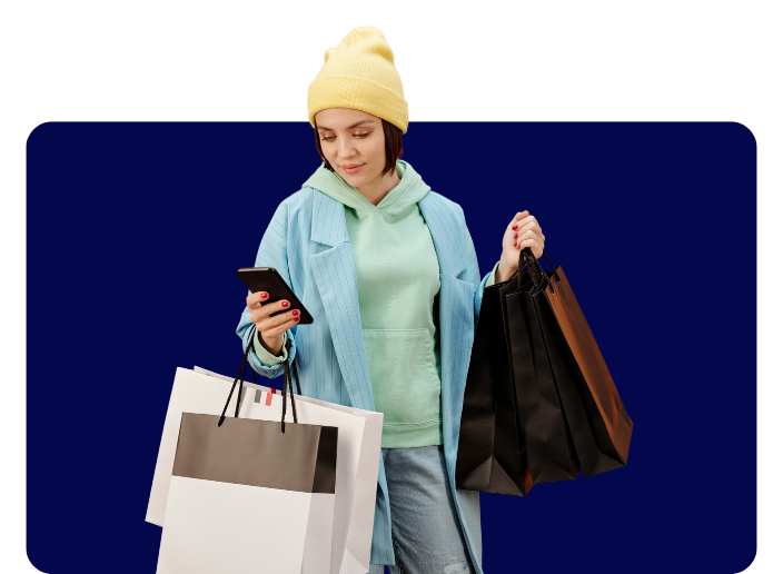 Female holiday shopper on phone with shopping bags