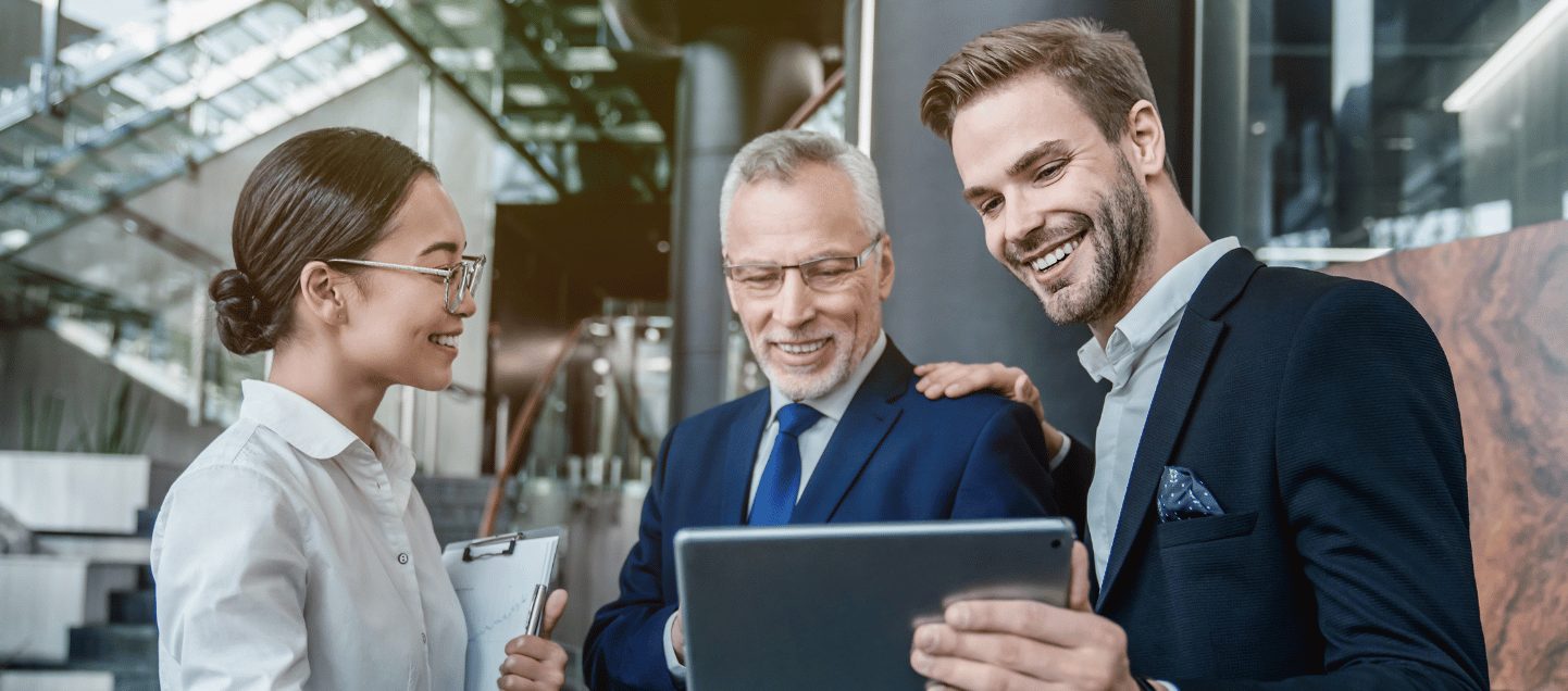 Group of coworkers in suits working together on digital tablet