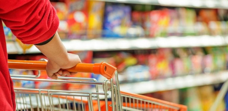 Hands on shopping cart in supermarket