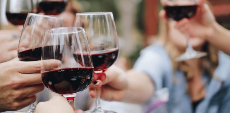 People cheering with red wine